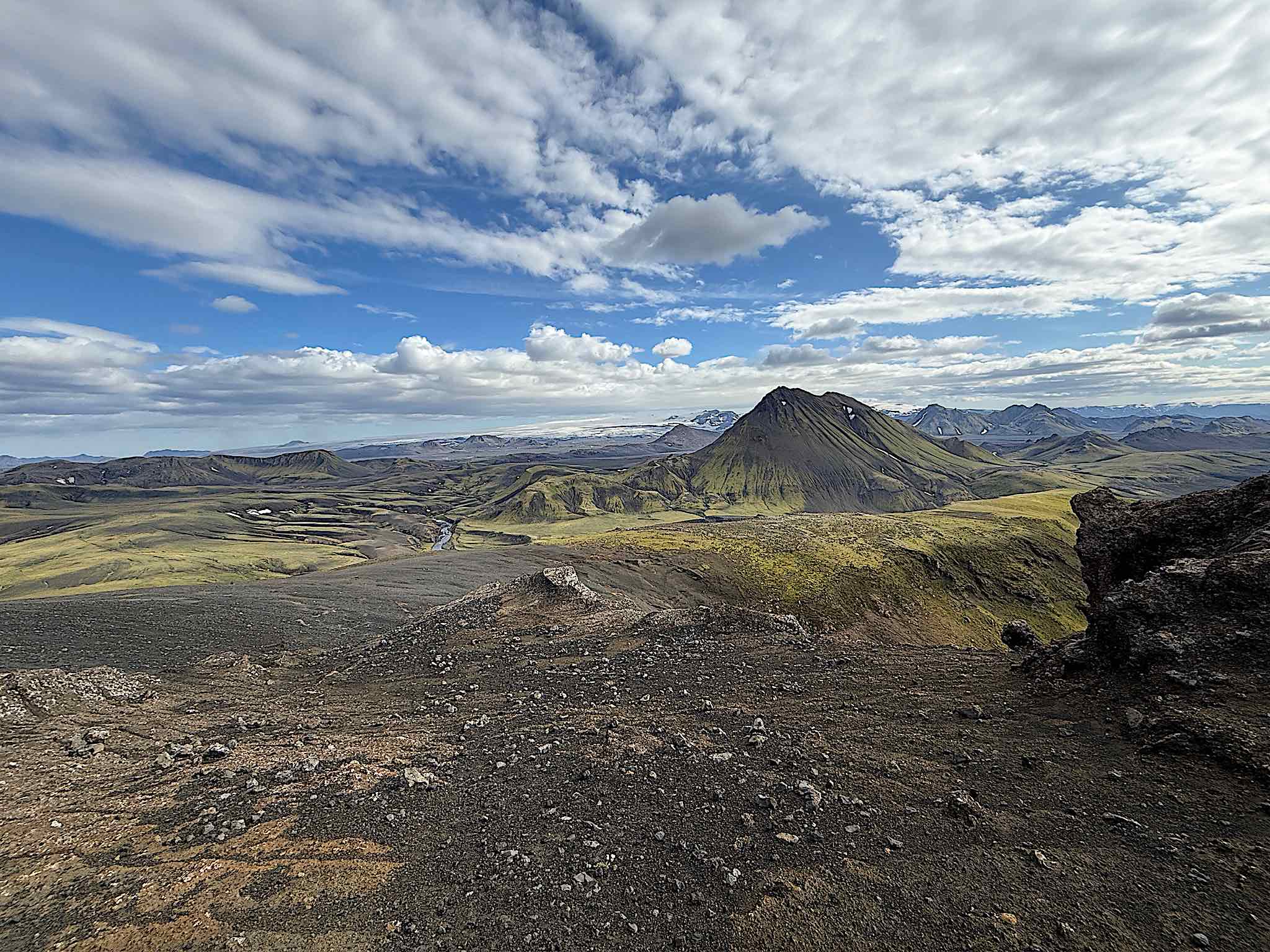 The Icelandic Highlands on the Laugavegur trail, green volcanic cone and glacier beyond