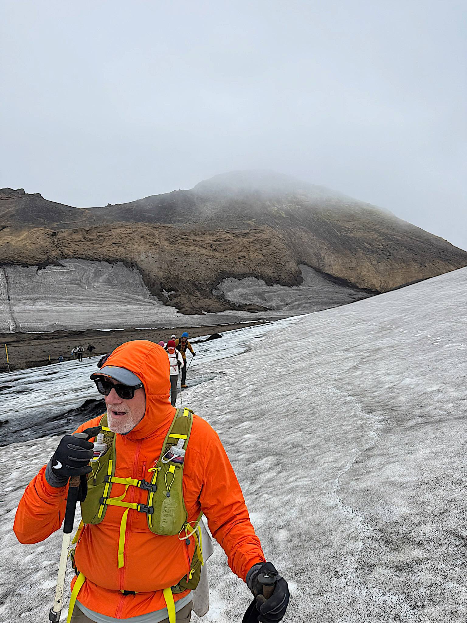 Hiker on the snowfield crossing Fimmvorduhals in cloud