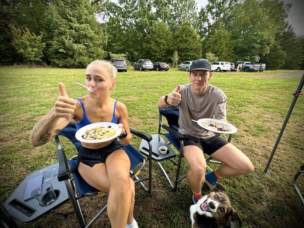Two runners giving a thumbs up over pancake plates at the finish