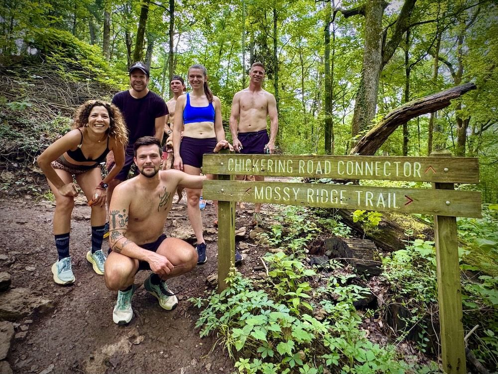 Trail runners at the Mossy Ridge Trail sign in Percy Warner Park